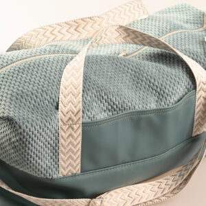 Reisetasche als handgemachtes Unikat mit Strukturstoff, Reißverschluss, Außentasche und gemustertem Schultergurt.